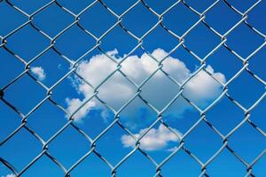 A cloud is seen through a chain link fence photo