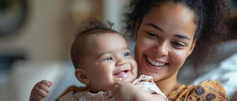 A woman is holding a baby and smiling photo