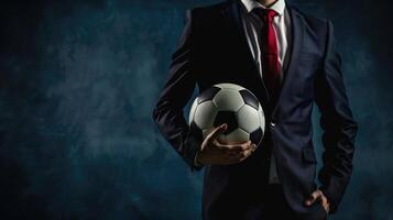 A football manager wear suit and red tie hand holding football photo