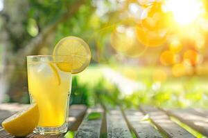 A glass of lemonade with a straw in it and a slice of lemon on the side photo