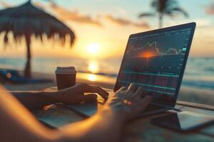 A person is sitting on a beach with a laptop open, working on a financial report photo