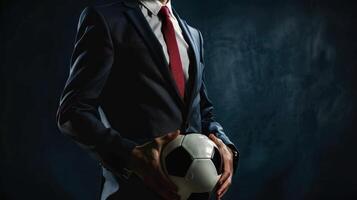 A football manager wear suit and red tie hand holding football photo