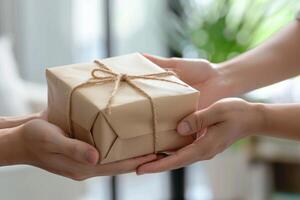 A person is holding a brown box with a string tied around it photo