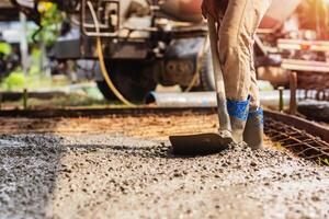 hombre es trabajando en un construcción sitio, utilizando un pala a moverse grava foto