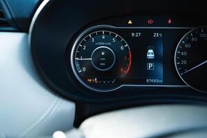 A car dashboard with a fuel gauge showing that the car is low on gas photo