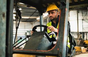 forklift driver sits in his vehicle in a warehouse and gives a thumbs up to show confidence in his work photo