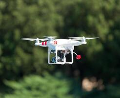 Flying helicopter with camera over the green field photo