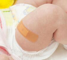 Leg of a newborn with the patch after vaccination. photo