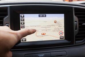 Navigation panel inside a car. Finger pointing on destination point. photo