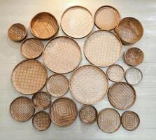 Many wicker tray wall hanging decoration on the concrete wall. The home interior decor photo