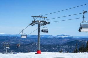 Chairlift in mountains during sunny winter day. photo