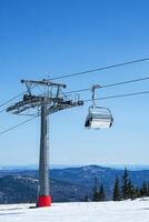 telesilla en montañas durante soleado invierno día. foto