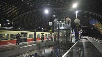 december 25, 2023. berlin, Tyskland. berlin huvud station tåg station interiör inuti i kväll på pendlare nivå gul färgad tåg och passagerare. berlin hauptbahnhof am abend und zug s-bahn. video