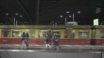 december 25, 2023. berlijn, duitsland. berlijn hoofd station trein station interieur binnen in avond Aan forens niveau geel gekleurde treinen en passagiers. berlijn centraal station ben abend ongedaan maken zug s-bahn. video