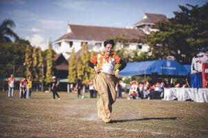 ChiangMai Thailand  November 30 2022  Asian teenage students are doing a sack race for unity in Chiang Mai Rajabhat University photo