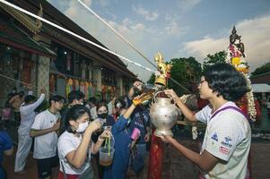 lámpara, Tailandia - mayo 04, 2023 budista personas unirse juntos a traer propicio agua a pagar saludos en el phra ese chedi hariphunchai foto