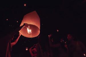 Chiang Mai - Thailand November 28, 2023  Tourists happily celebrate releasing lanterns at the Loi Krathong Yi Peng Lantern Festival according to Thai cultural traditions. photo