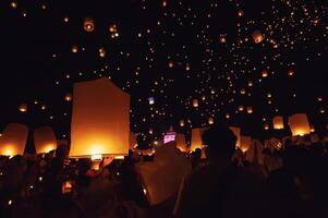 Chiang Mai - Thailand November 27, 2023. Tourists happily celebrate releasing lanterns at the Loi Krathong Yi Peng Lantern Festival according to Thai cultural traditions. photo