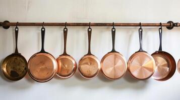 un conjunto de cobre utensilios de cocina colgando en un montado en la pared maceta estante ambos funcional y elegante para ninguna hogar cocinero foto