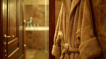 A plush bathrobe hangs on the back of a nearby door inviting the man to wrap up in it after his bath photo