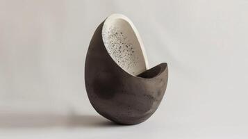 An abstract ceramic sculpture featuring a blend of clay and concrete showcasing the unique combination of rough and smooth textures. photo