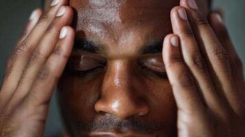 A closeup of a mans hands massaging a soothing blend of peppermint and rosemary essential oils onto his temples easing tension and headaches photo