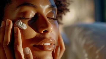 A woman applying moisturizer to her face her silk pillowcase visible in the background symbolizing the benefits of beauty sleep photo