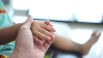 langzaam beweging, detailopname van een vader hand- Holding zijn zoon's hand. video