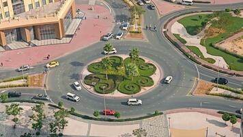 uae, dubai - Unidos árabe Emirados 01 abril 2024 aéreo Visão do uma rotunda dentro a cidade, Careca perspectiva do uma rotunda com exuberante vegetação e passagem veículos. video