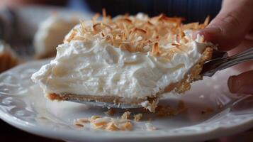 A friend trying to sneak a bite of a deliciouslooking coconut cream pie before its time for dessert photo