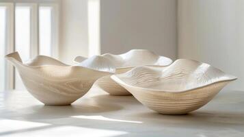 A series of delicate translucent porcelain bowls that have been sculpted and stretched using a technique known as mishima where designs are etched into the surface and then filled with photo