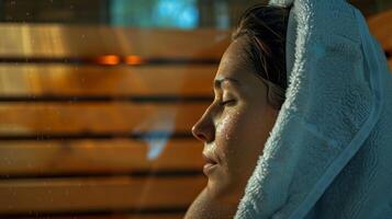 A closeup of the vlogger wiping their sweat after a session in the sauna emphasizing the detoxifying aspect of using one. photo