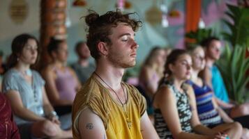 The workshop takes a moment to pause and practice a breathing exercise with the instructor reminding everyone to take deep intentional breaths photo