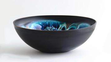 A ceramic bowl with a dark matte exterior contrasted by a vibrant and glossy interior created through soda vaporization in the firing process. photo
