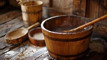 A wooden ladle and bucket filled with water sit on the floor ready for the next round of steam. photo