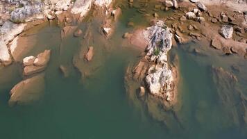 Aerial view over tranquil water and weathered rocks in the Annamite Range, Vietnam, highlighting natural erosion and serene landscapes for documentary backgrounds video