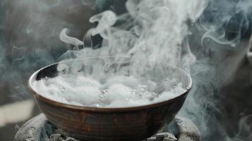 A closeup of steam rising from a bowl of water on hot coals creating a moist and soothing environment for easier breathing. photo