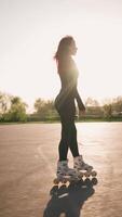 achterzijde visie slank vrouw met mooi figuur skaten Aan asfalt in stad park video