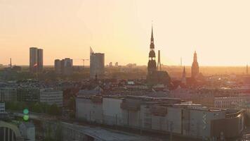 aéreo panorámico puesta de sol terminado riga antiguo pueblo en letonia hermosa primavera puesta de sol terminado riga. dorado hora fuego puesta de sol. video