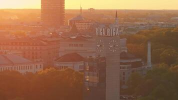 aérien panoramique le coucher du soleil plus de riga vieux ville dans Lettonie. magnifique printemps le coucher du soleil plus de Riga. riga l'horloge la tour proche en haut vue près le train gare. d'or heure Feu le coucher du soleil. video