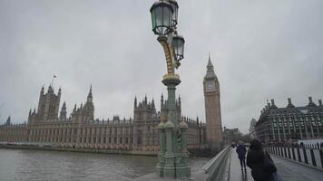 London, United Kingdom - April 2, 2024 - The Thames River in London with Westminster Bridge, Big Ben and the Houses of Parliament and and iconic AEC Routemaster red double-decker buses video
