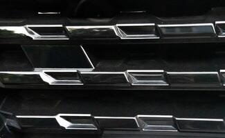 Close-Up of a Car's Black Grille with Chrome Accents photo