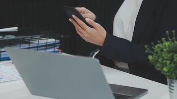 Asian businesswoman in formal suit in office happy and cheerful during using smartphone and working video