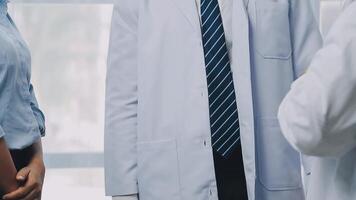 Multiracial medical team having a meeting with doctors in white lab coats and surgical scrubs seated at a table discussing a patients records, Medical team checking Xray results. video