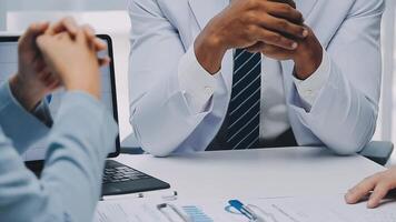 Multiracial medical team having a meeting with doctors in white lab coats and surgical scrubs seated at a table discussing a patients records, Medical team checking Xray results. video