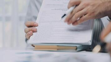 Multiracial medical team having a meeting with doctors in white lab coats and surgical scrubs seated at a table discussing a patients records, Medical team checking Xray results. video