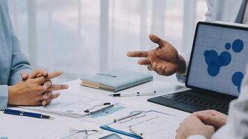 Multiracial medical team having a meeting with doctors in white lab coats and surgical scrubs seated at a table discussing a patients records, Medical team checking Xray results. video