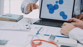 Multiracial medical team having a meeting with doctors in white lab coats and surgical scrubs seated at a table discussing a patients records, Medical team checking Xray results. video