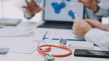 Multiracial medical team having a meeting with doctors in white lab coats and surgical scrubs seated at a table discussing a patients records, Medical team checking Xray results. video