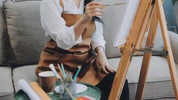 sobre a ombro seletivo foco tiro do masculino artista usando escova enquanto adicionando cor pintura para lápis desenhando em tela de pintura video
